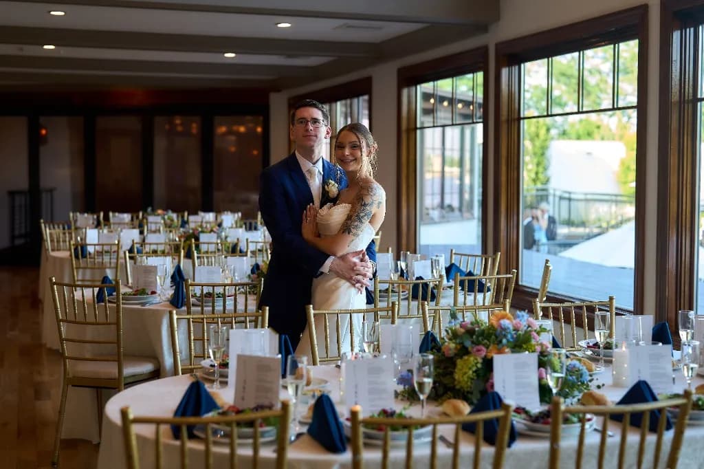 Yacht Clubs on Long Island, Bride and groom portrait in the ballroom with string lights at the Riviera Waterfront Mansion