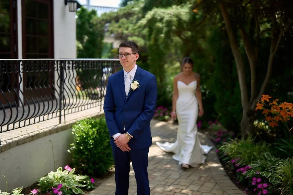 Bride and groom embrace on the waterfront lawn at the Riviera Waterfront Mansion